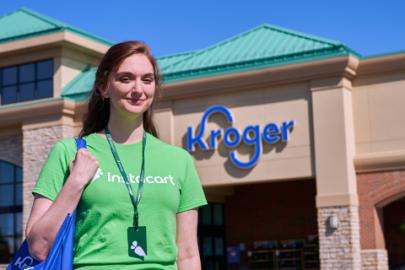 a person wearing a green shirt standing in front of a building
