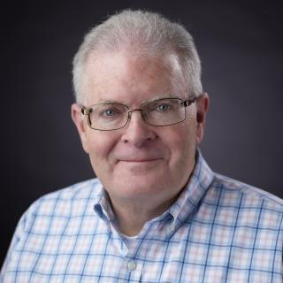 a man wearing glasses and looking at the camera