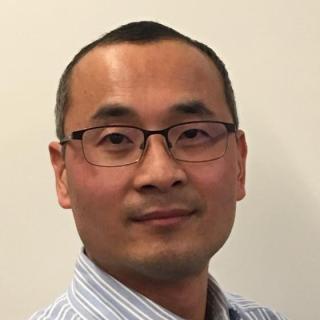a man wearing glasses and smiling at the camera