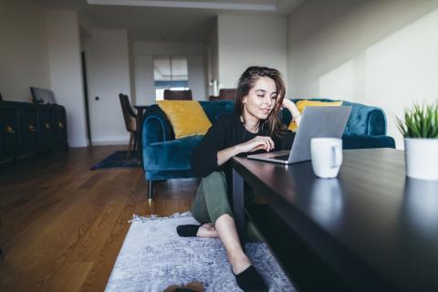 a person sitting at a table using a laptop