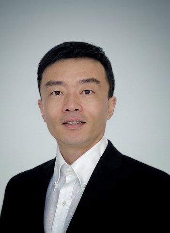 a man wearing a suit and tie smiling at the camera