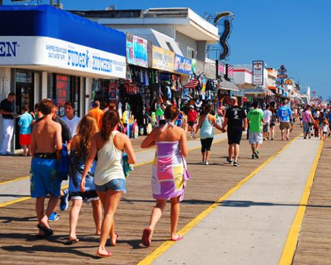 a group of people walking down a sidewalk in front of a crowd