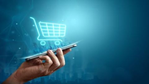 ecommerce shopping cart coming out of phone being held in hand