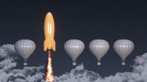 Orange rocket ship next to white hot air balloon