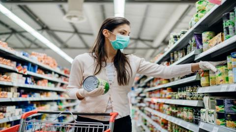 Woman shopping during the pandemic wearing a mask and gloves at the grocery store