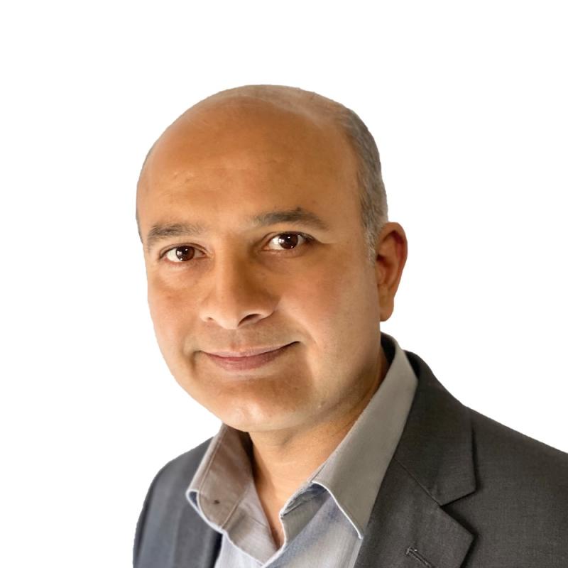 a man wearing a suit and tie smiling at the camera