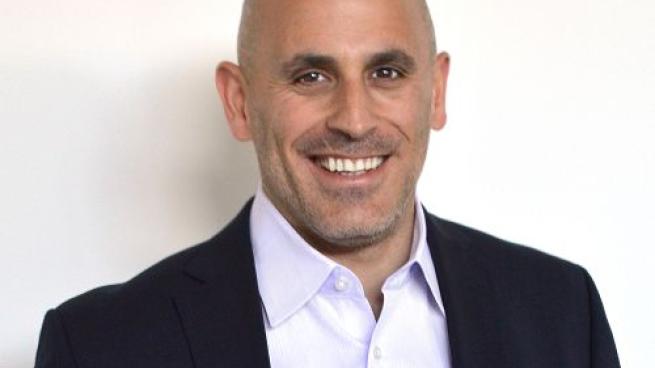 Marc Lore wearing a suit and tie smiling at the camera