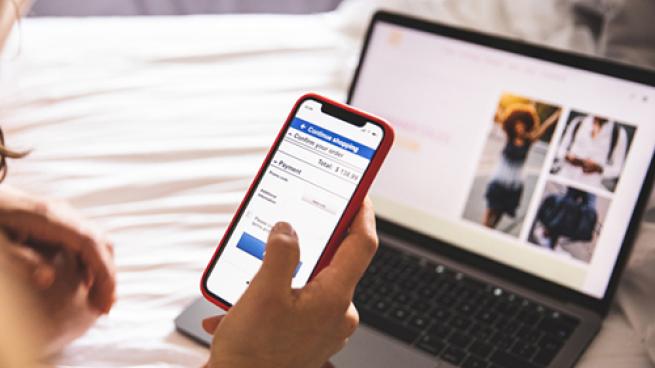 a person sitting on a bed using a laptop