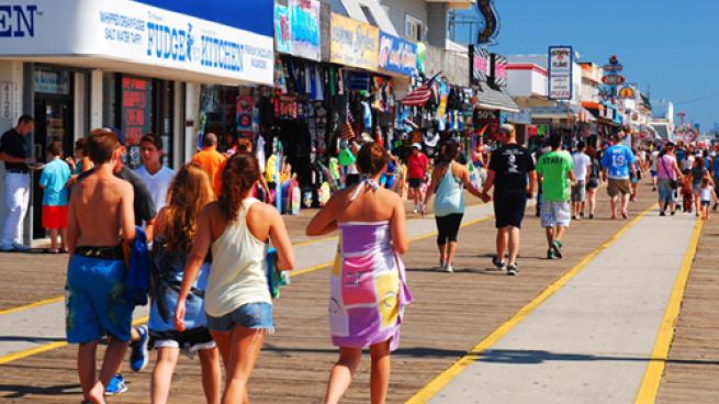 a group of people walking down a sidewalk in front of a crowd